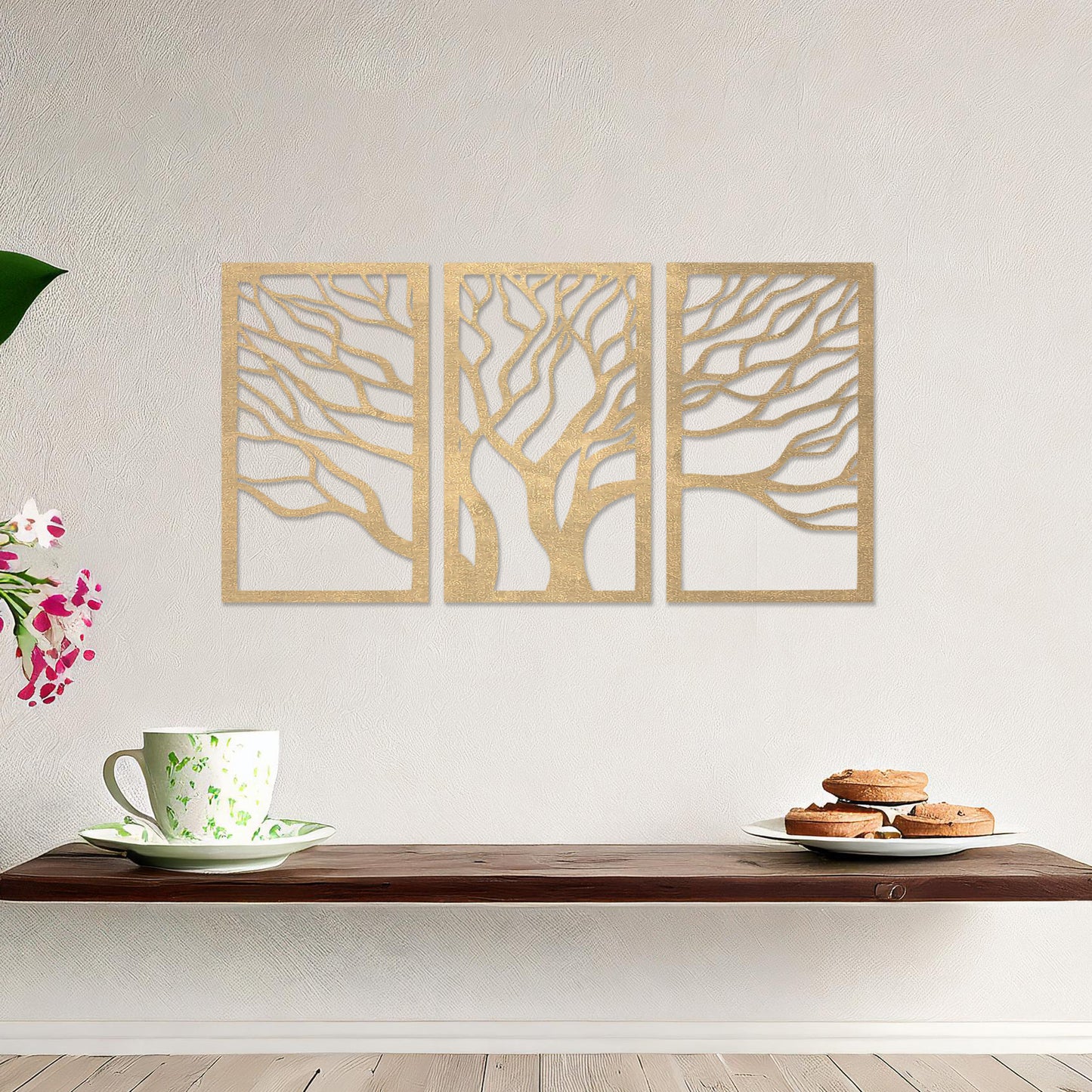 A three-panel wall art featuring a minimalist tree design with flowing, intricate branches. The artwork is displayed on a neutral wall in a modern living room, complementing the contemporary decor and adding a touch of natural elegance.