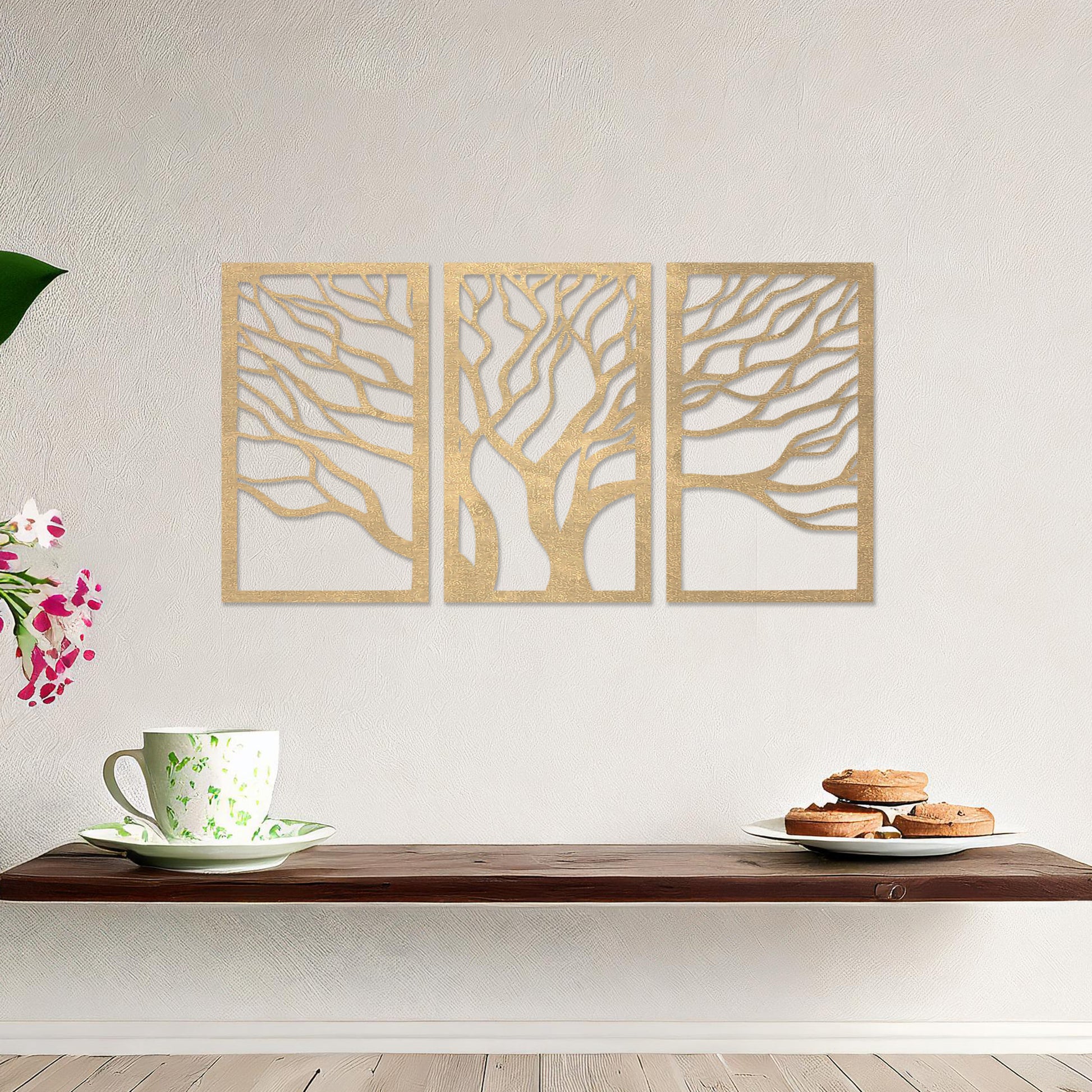 A three-panel wall art featuring a minimalist tree design with flowing, intricate branches. The artwork is displayed on a neutral wall in a modern living room, complementing the contemporary decor and adding a touch of natural elegance.