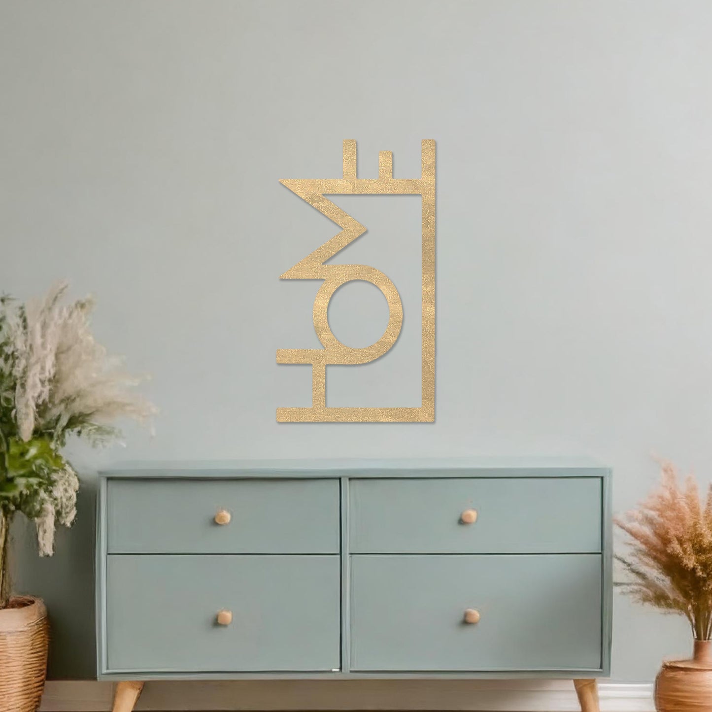 Wall art featuring the word "HOME" in a bold, modern design with geometric shapes integrated into the lettering. The piece is displayed on a neutral wall within contemporary room decor, adding a stylish and welcoming touch to the space.