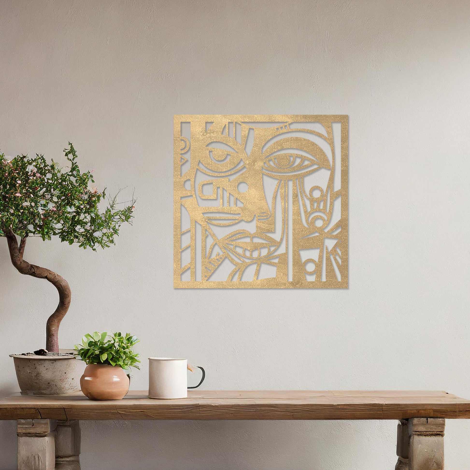 Wall art featuring an abstract face design with geometric patterns and intricate details, creating a modern and artistic composition. The piece is displayed on a neutral wall within rustic-modern decor, adding a bold and expressive focal point to the space.