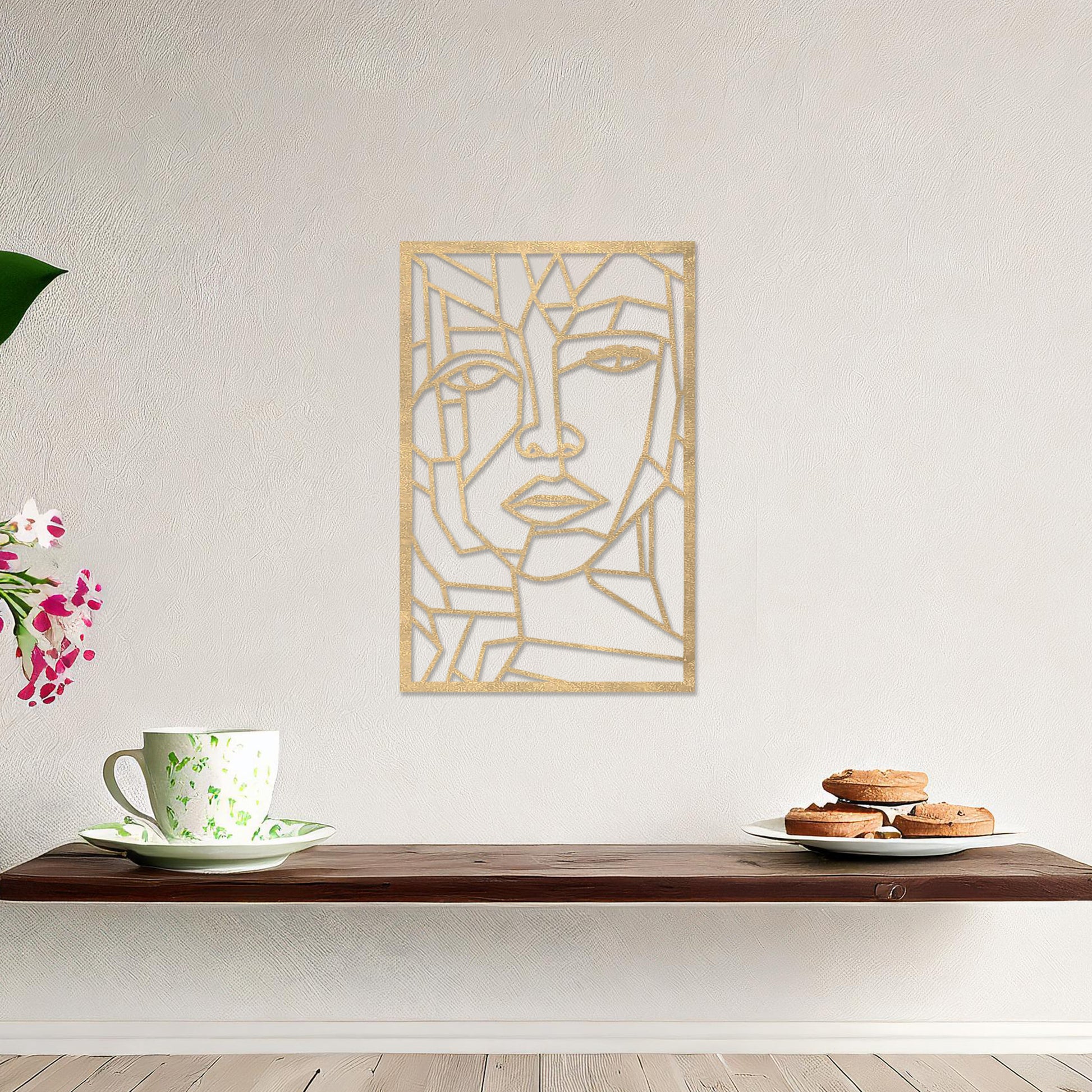 Wall art featuring a geometric abstract face design with sharp angular lines forming a modern and artistic composition. The piece is displayed on a neutral wall within contemporary decor, adding a bold and creative focal point to the space.