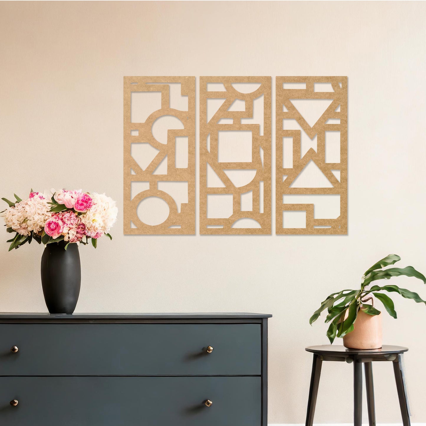 This image features a vibrant, modern triptych wall art design made of geometric shapes and patterns. The bold black designs contrast against a light green wall, complementing the stylish sofa below.
