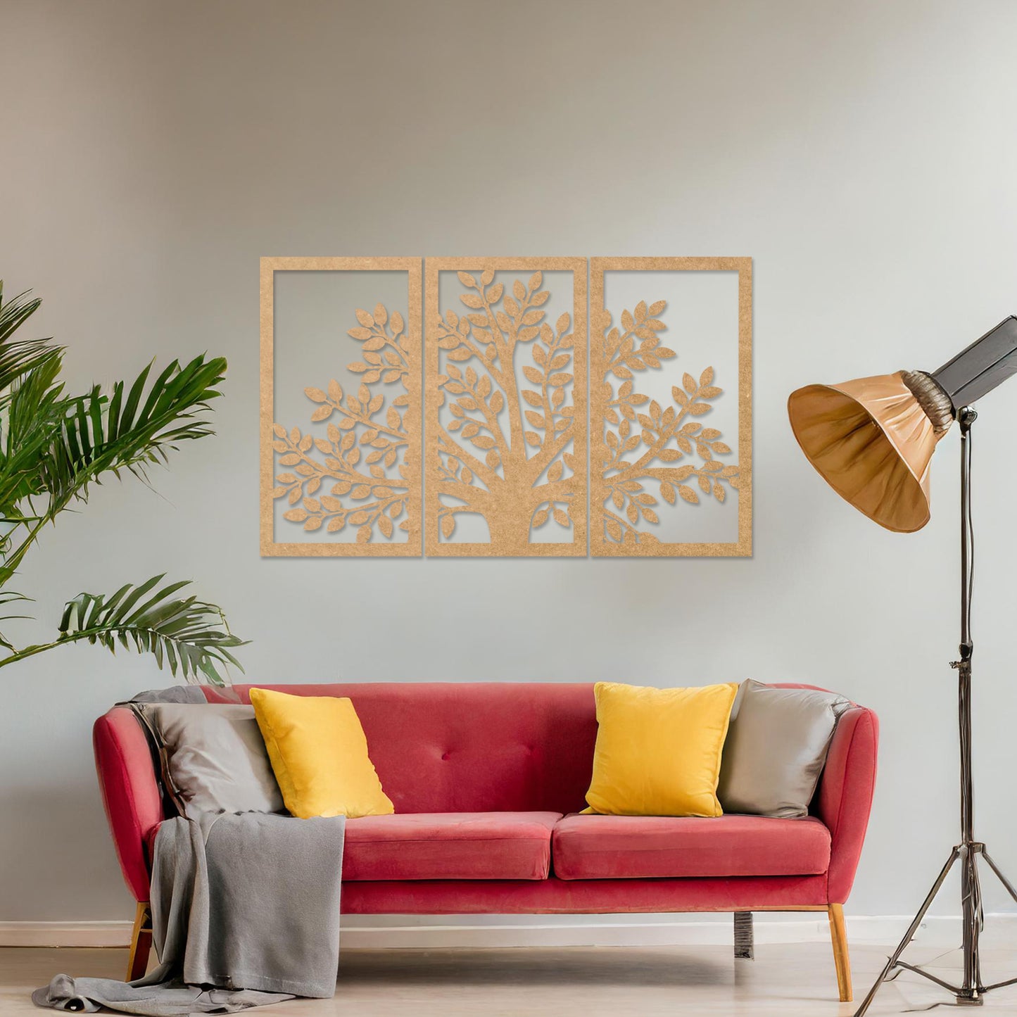 Wooden wall art comprising three panels featuring a tree design with detailed leaves and branches, displayed on a neutral wall within modern room decor, showcasing its intricate and natural craftsmanship.