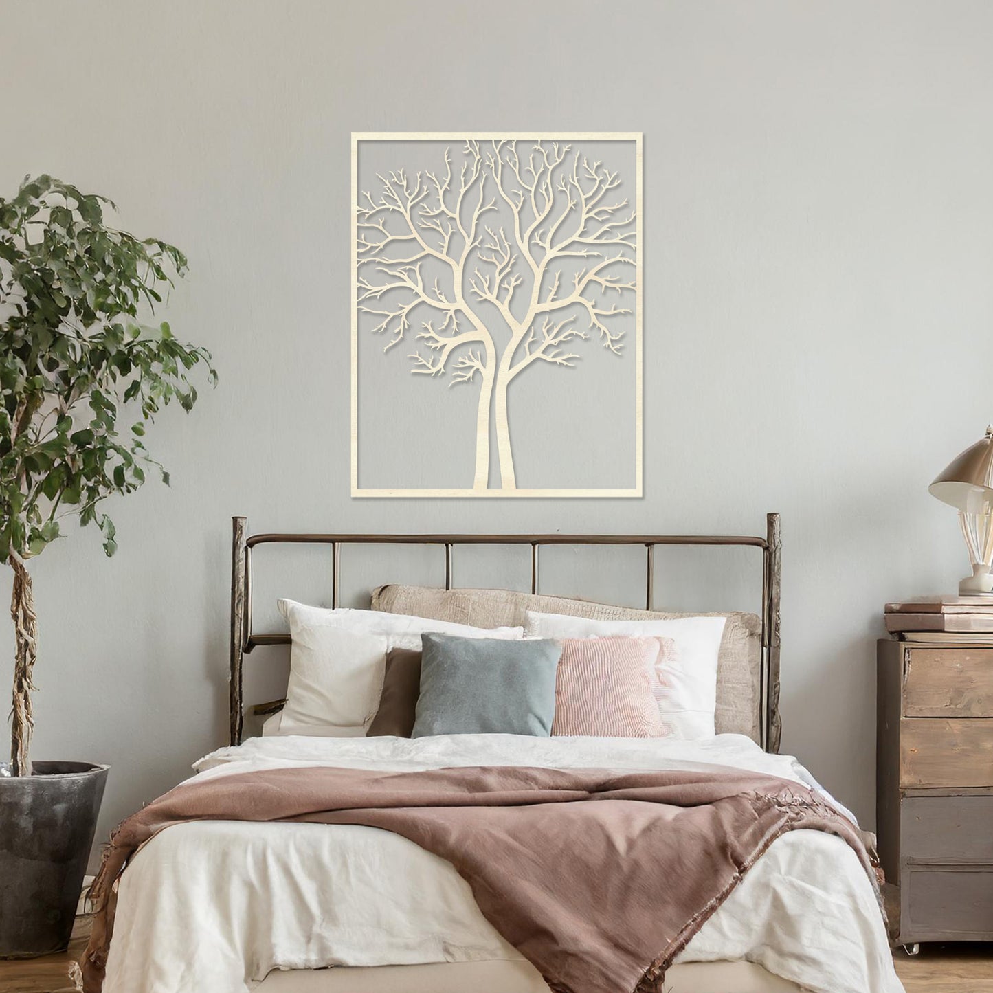 Wooden wall art featuring a minimalist tree design with bare branches, displayed on a neutral wall within modern room decor, highlighting its elegant and natural craftsmanship.