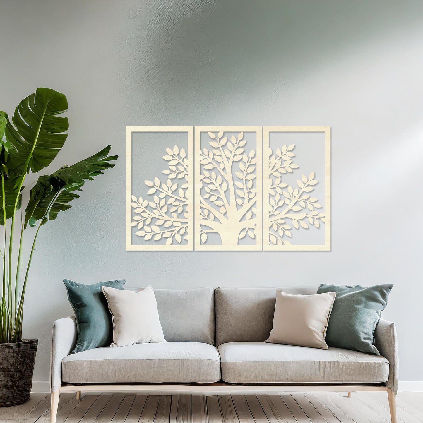 Wooden wall art comprising three panels featuring a tree design with detailed leaves and branches, displayed on a neutral wall within modern room decor, showcasing its intricate and natural craftsmanship.
