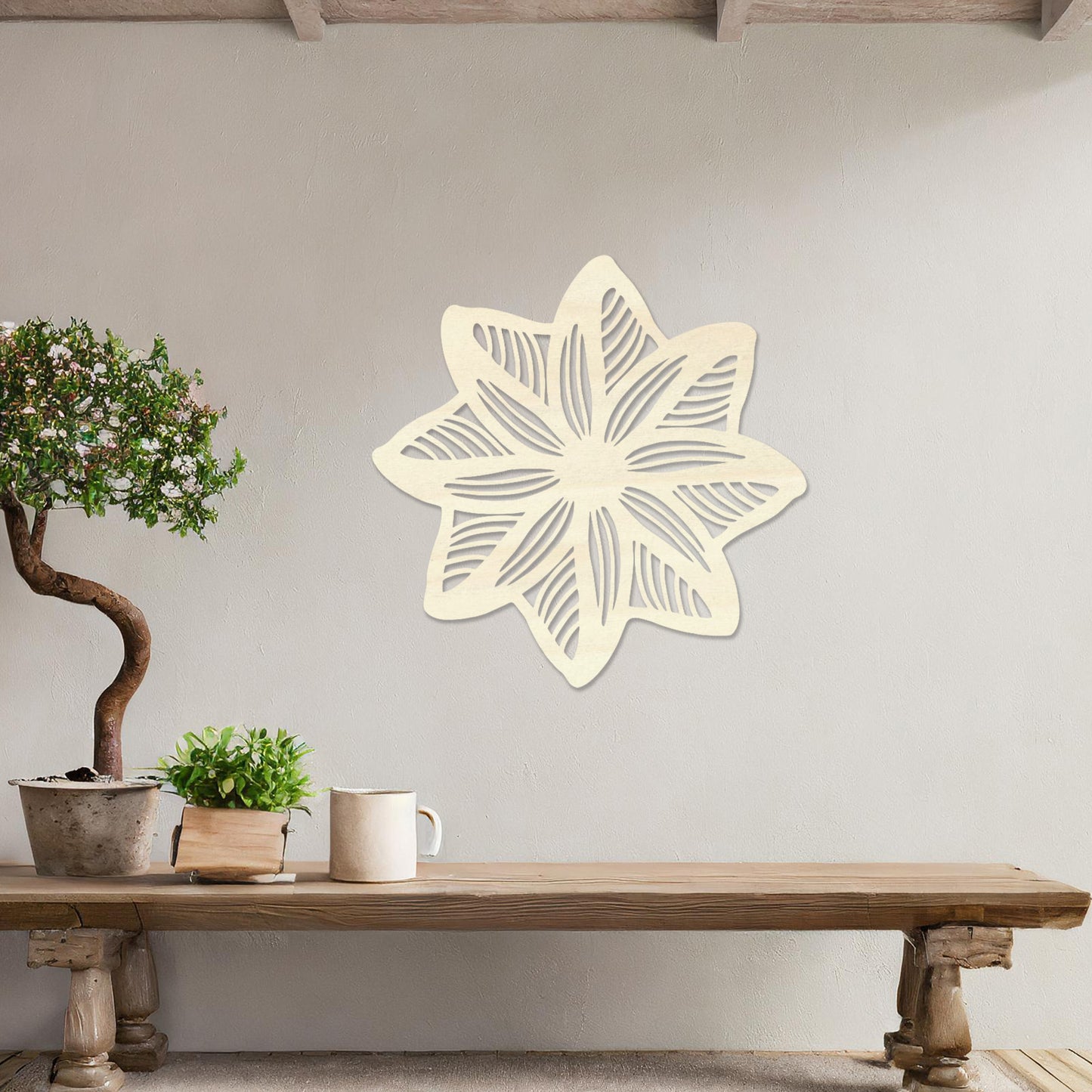 Wall art featuring a star-shaped floral design with layered petals and intricate cut-out patterns. The piece is displayed on a neutral wall within modern decor, adding a unique and decorative focal point to the space.