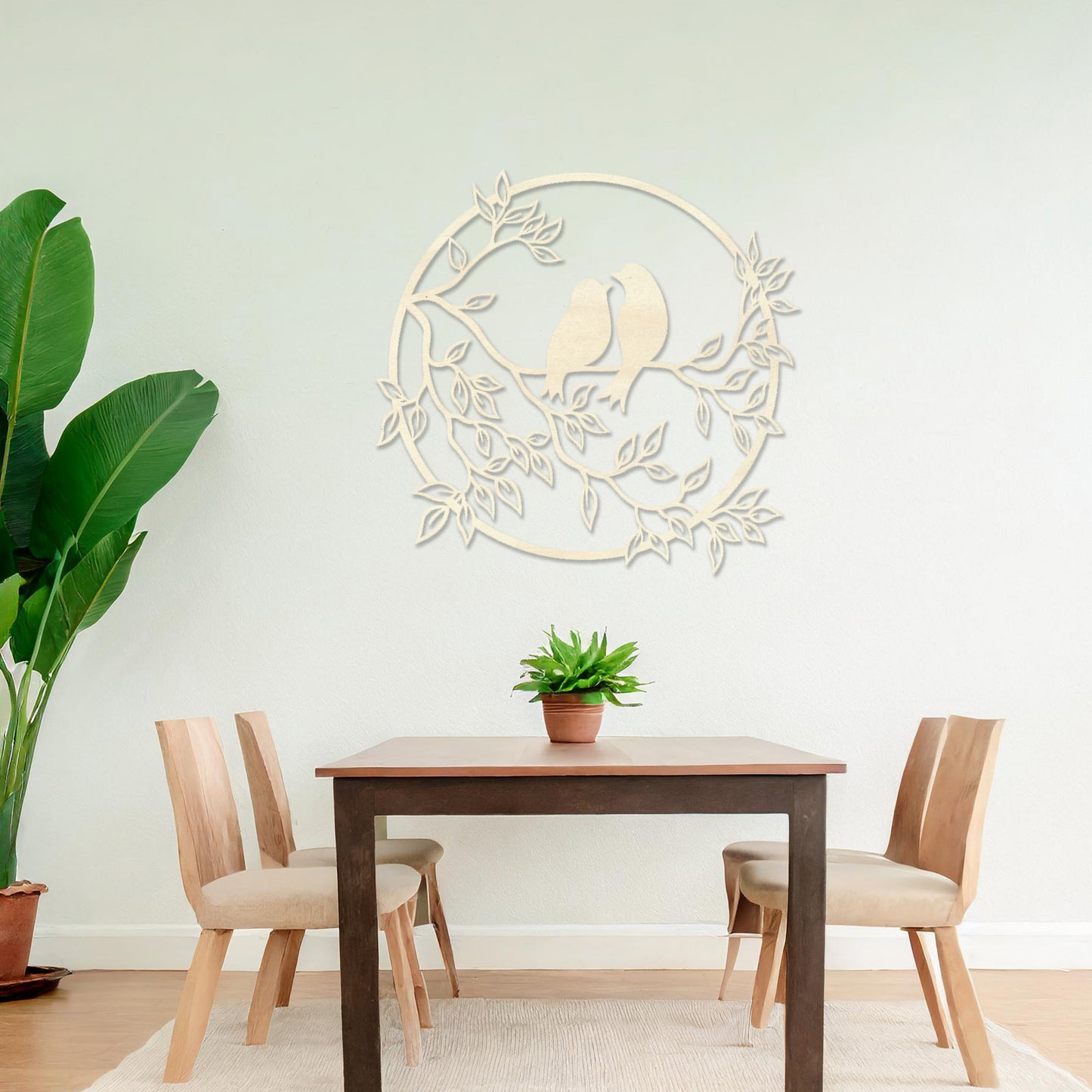 Wooden wall art featuring a circular design with two birds perched on a branch surrounded by leaves, displayed on a neutral wall within modern room decor, showcasing its delicate and nature-inspired craftsmanship.