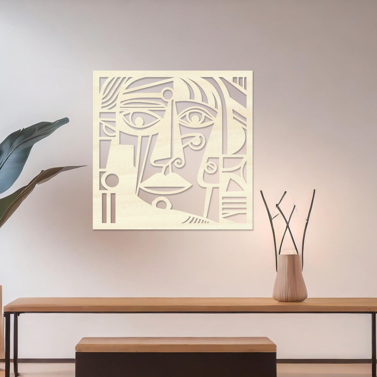 Wall art featuring an abstract face design with bold geometric shapes and intricate linework. The piece is displayed on a neutral wall within modern decor, adding an artistic and expressive focal point to the space.
