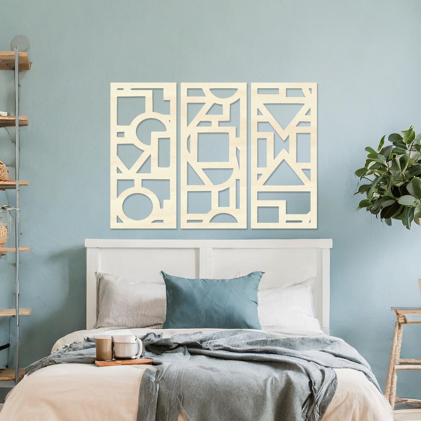 This image features a vibrant, modern triptych wall art design made of geometric shapes and patterns. The bold black designs contrast against a light green wall, complementing the stylish sofa below.