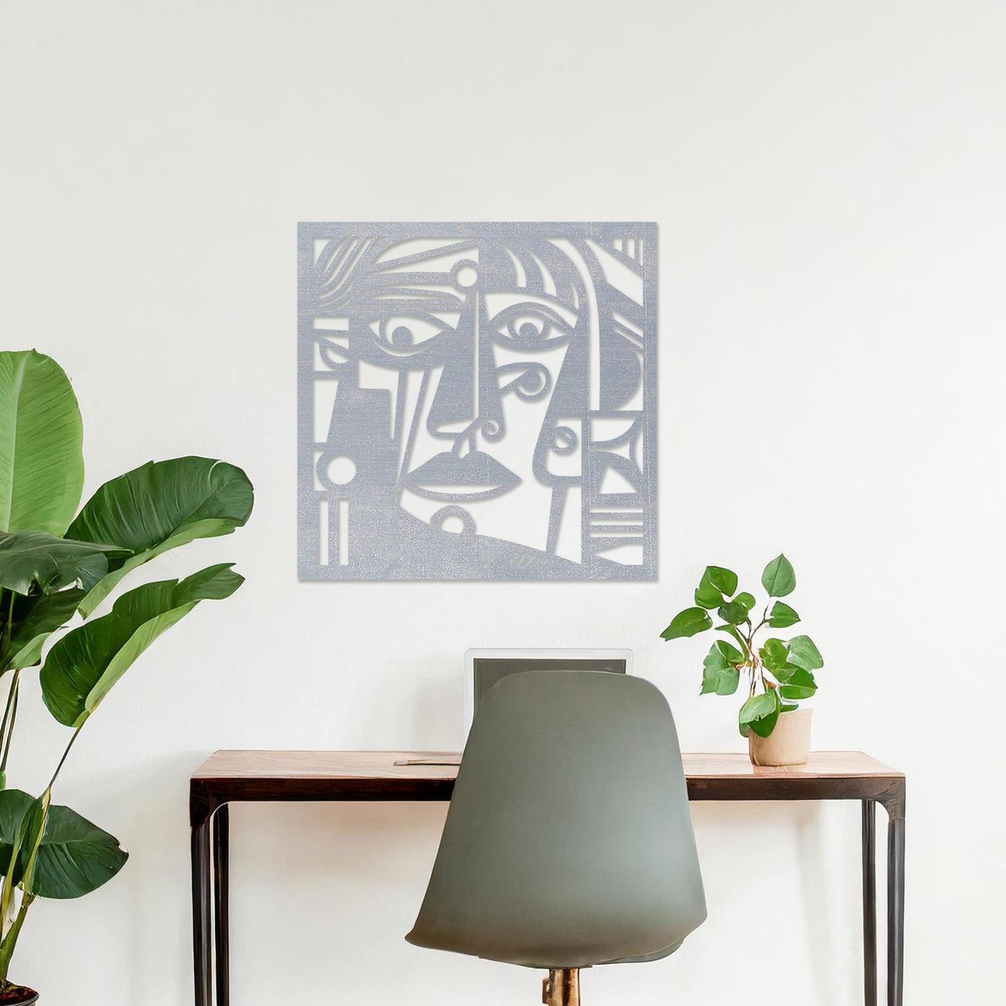 Wall art featuring an abstract face design with bold geometric shapes and intricate linework. The piece is displayed on a neutral wall within modern decor, adding an artistic and expressive focal point to the space.
