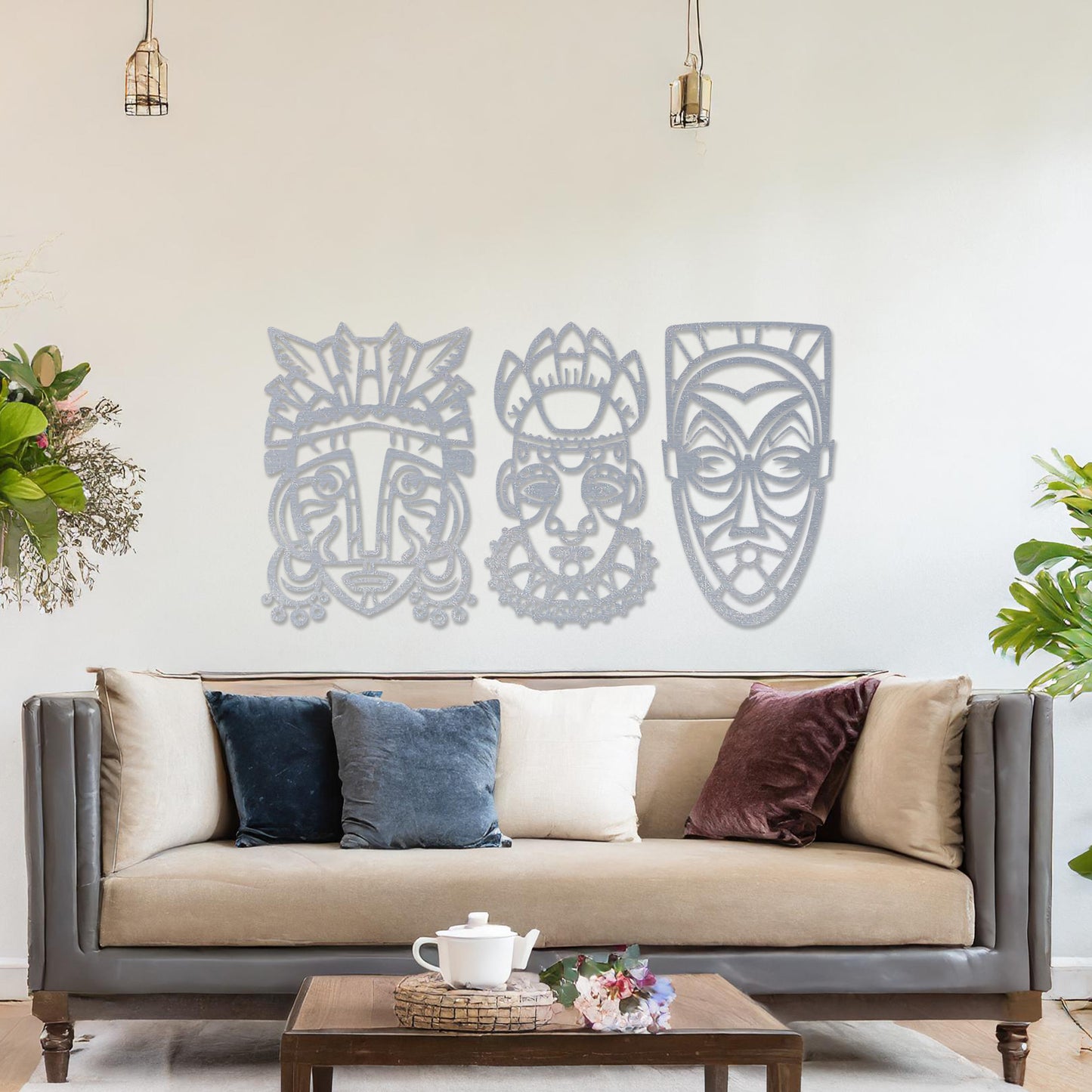 This is a wall art design featuring three tribal masks with intricate details, displayed on a neutral wall. The masks' features and patterns create an eye-catching, cultural focal point, enhancing the modern room's decor.