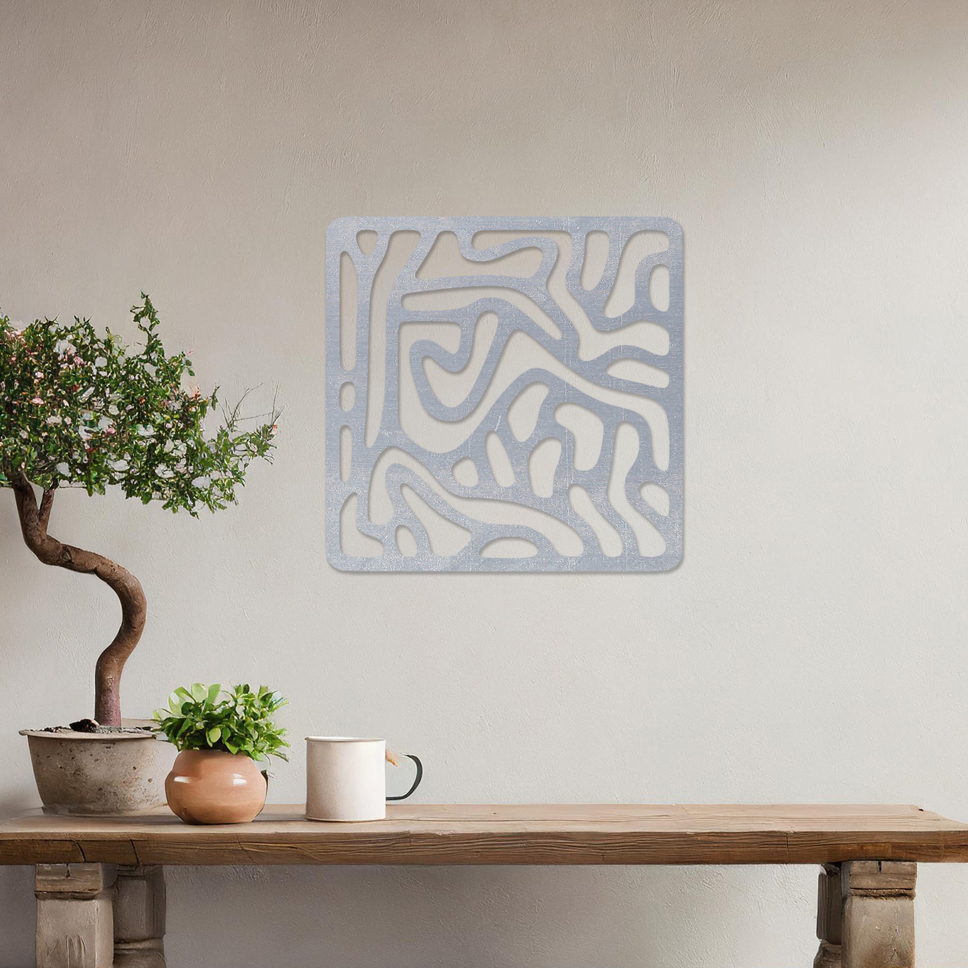 Wall art featuring an abstract design with flowing, interconnected organic shapes forming a bold pattern. The piece is displayed on a neutral wall within modern decor, adding a contemporary and artistic touch to the space.