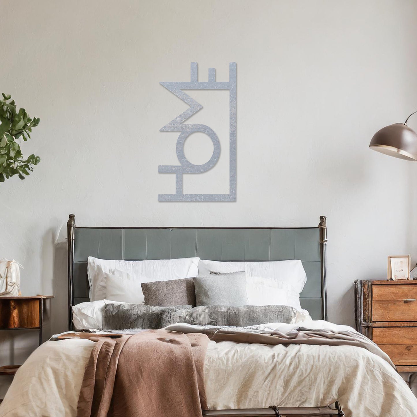 Wall art featuring the word "HOME" in a bold, modern design with geometric shapes integrated into the lettering. The piece is displayed on a neutral wall within contemporary room decor, adding a stylish and welcoming touch to the space.