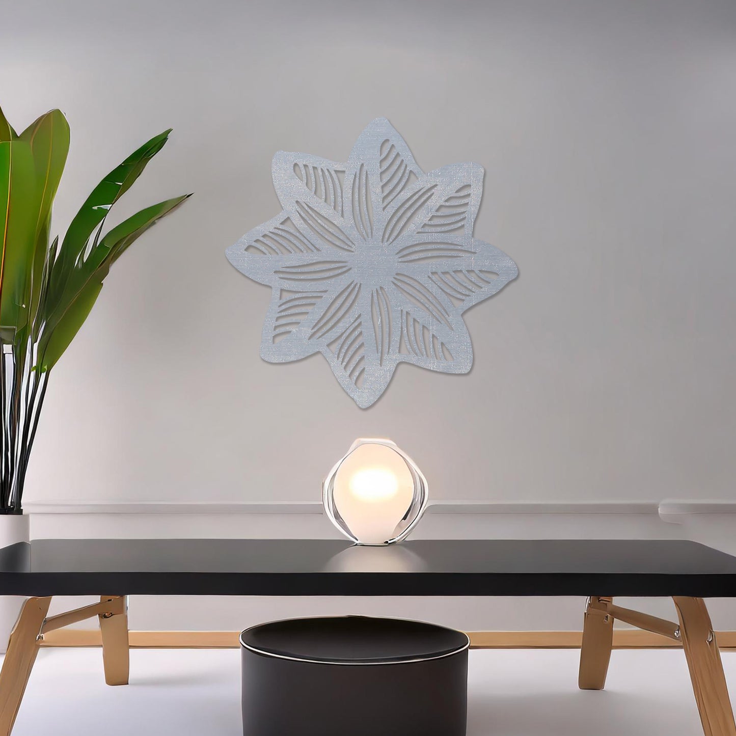 Wall art featuring a star-shaped floral design with layered petals and intricate cut-out patterns. The piece is displayed on a neutral wall within modern decor, adding a unique and decorative focal point to the space.