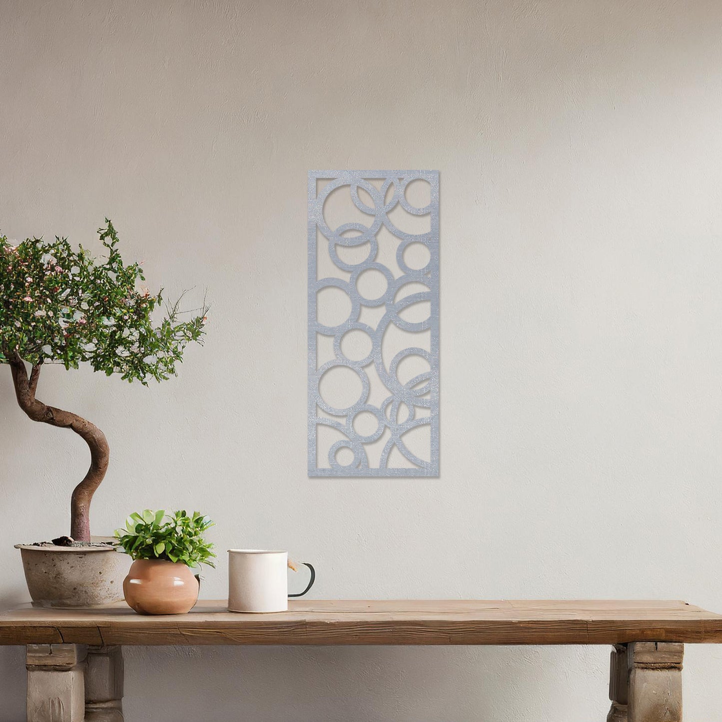 A rectangular wall art piece featuring an abstract design of overlapping circles of various sizes. The artwork is displayed on a neutral wall in a modern room,