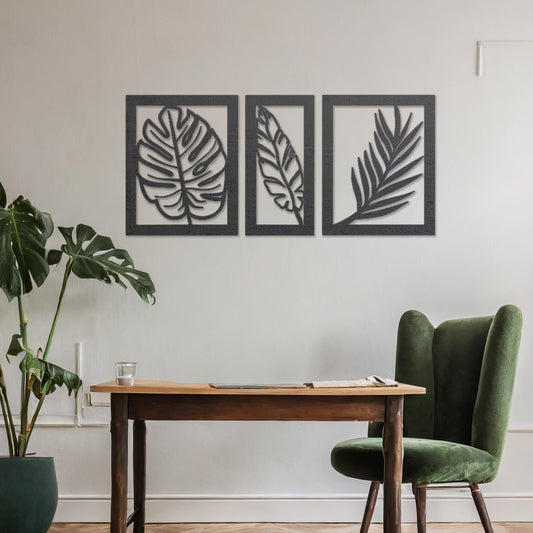 Wooden wall art set featuring three framed botanical designs with detailed leaf patterns, including monstera and palm leaves. The artwork is displayed on a neutral wall within modern room decor, adding a natural and elegant touch.