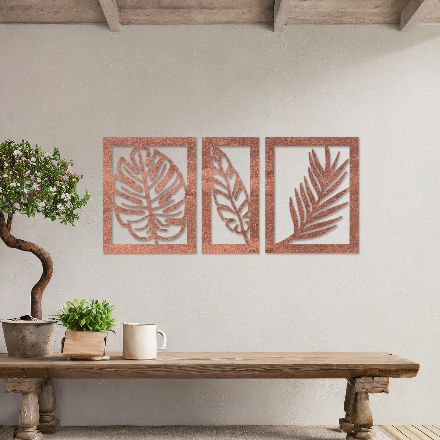 Wooden wall art set featuring three framed botanical designs with detailed leaf patterns, including monstera and palm leaves. The artwork is displayed on a neutral wall within modern room decor, adding a natural and elegant touch.