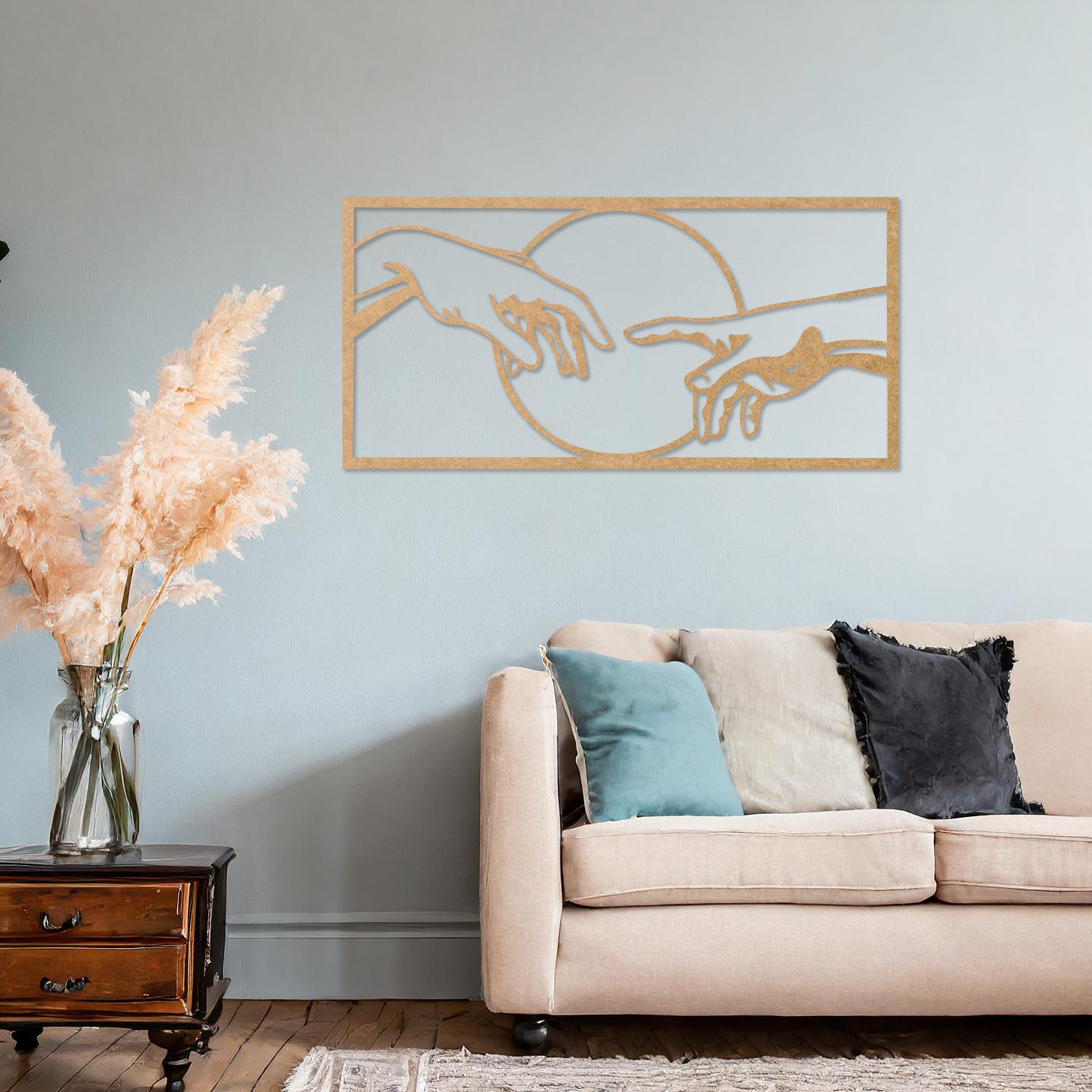 Wooden wall art featuring a minimalist depiction of two hands reaching out towards each other, framed by a circular design. Mounted on a neutral wall within modern room decor, this piece adds an artistic and meaningful touch to any space.