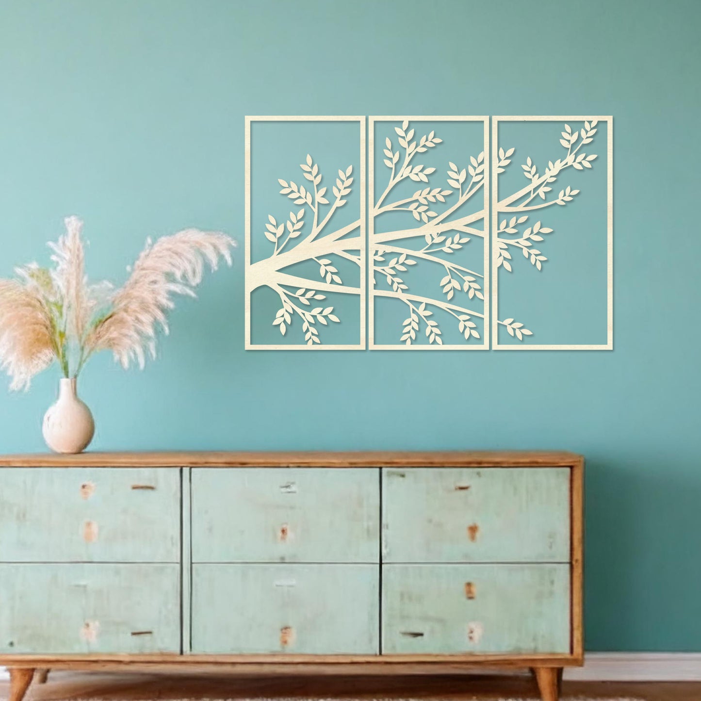 Wooden wall art featuring a three-panel design of a branching tree with delicate leaves extending gracefully across each panel. Mounted on a neutral wall within modern decor, this piece evokes a sense of natural elegance and harmony.