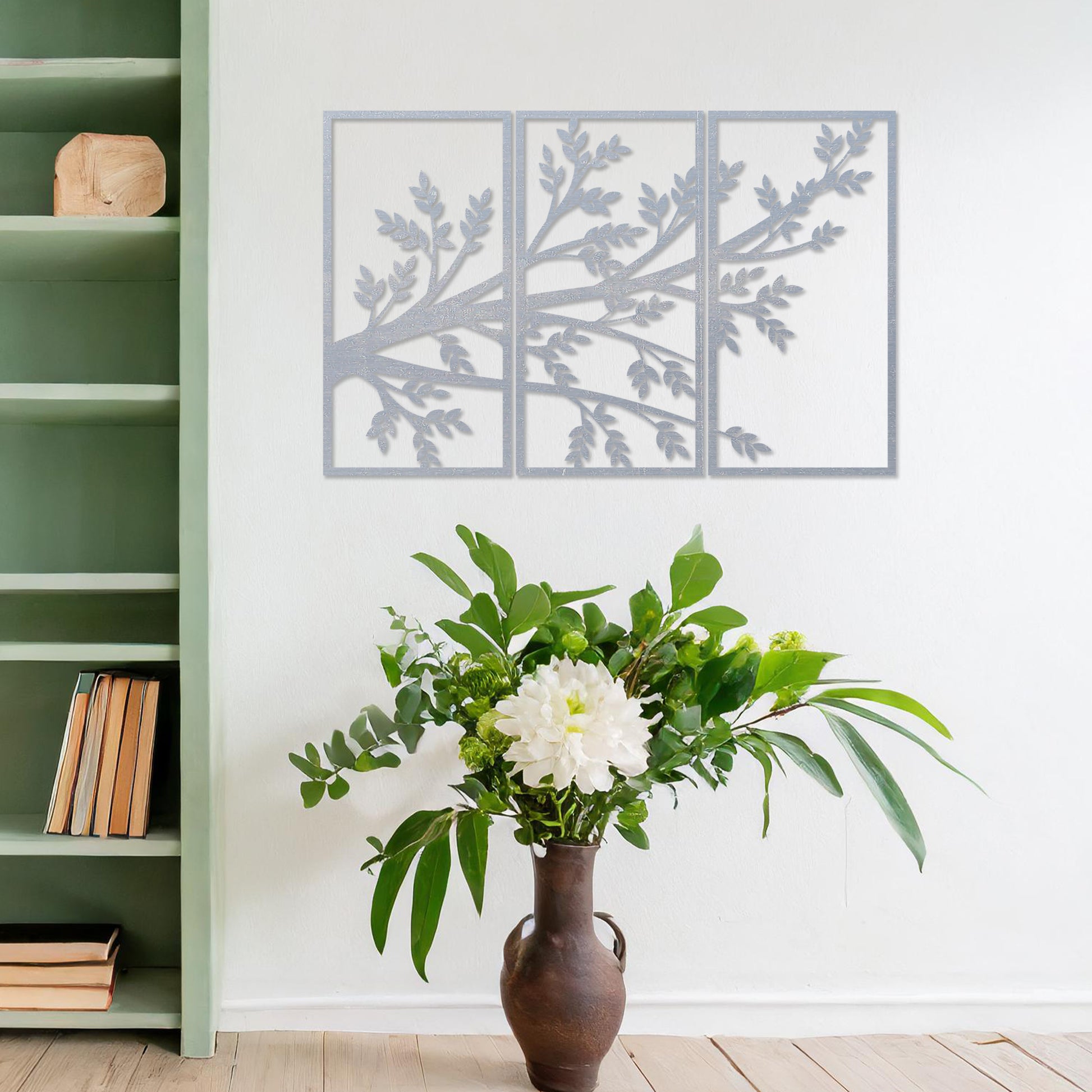 Wooden wall art featuring a three-panel design of a branching tree with delicate leaves extending gracefully across each panel. Mounted on a neutral wall within modern decor, this piece evokes a sense of natural elegance and harmony.