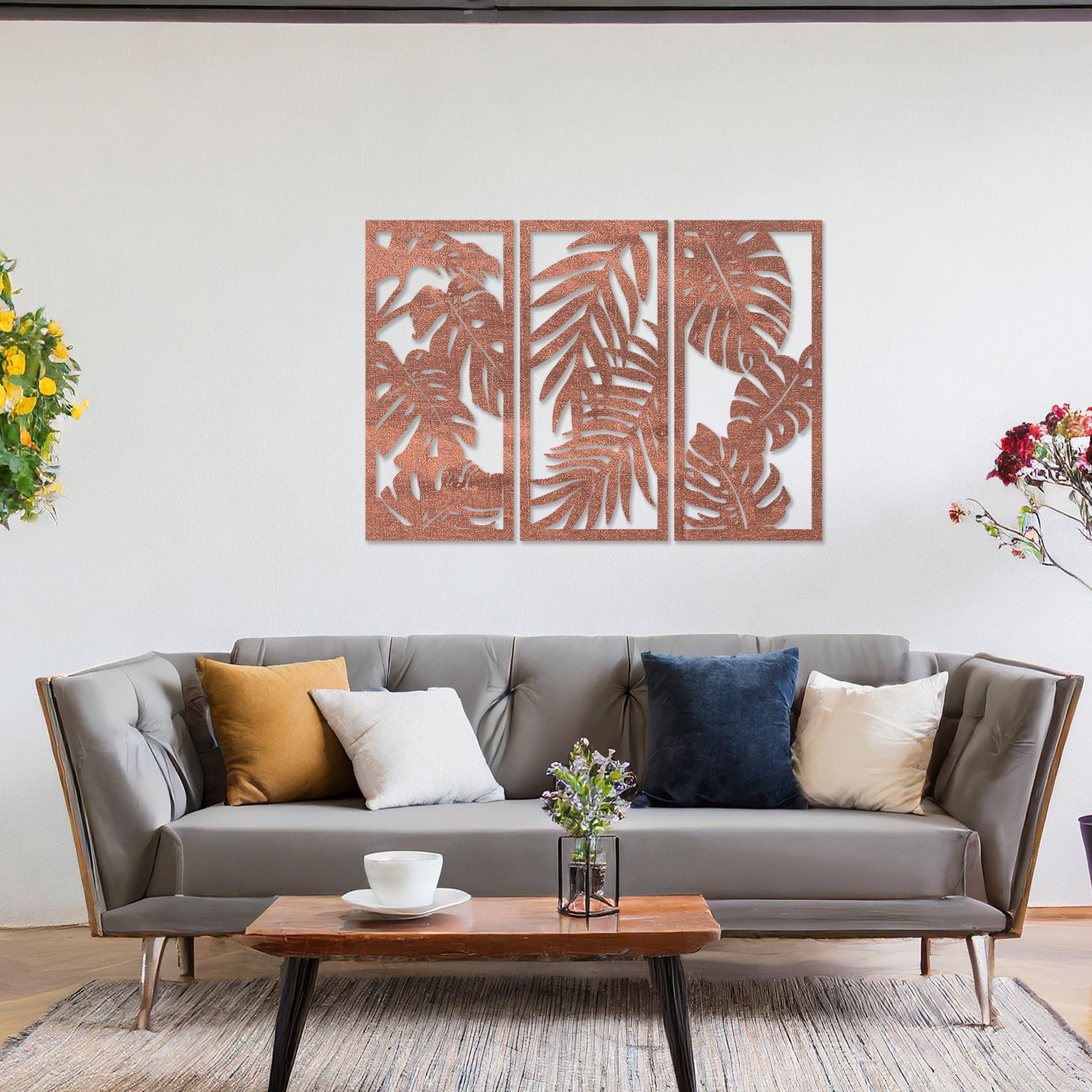A set of three wooden wall panels featuring intricate tropical leaf designs, creating a cohesive and elegant decorative piece. Displayed on a neutral wall within modern room decor, this artwork brings a touch of nature indoors.