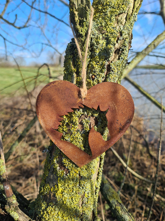 This rustic heart-shaped ornament features a detailed silhouette of a horse's head cut out in the center. The weathered, rusted finish adds a natural charm, while the jute twine provides a simple yet elegant way to hang it. Perfect for outdoor or rustic-themed decor.