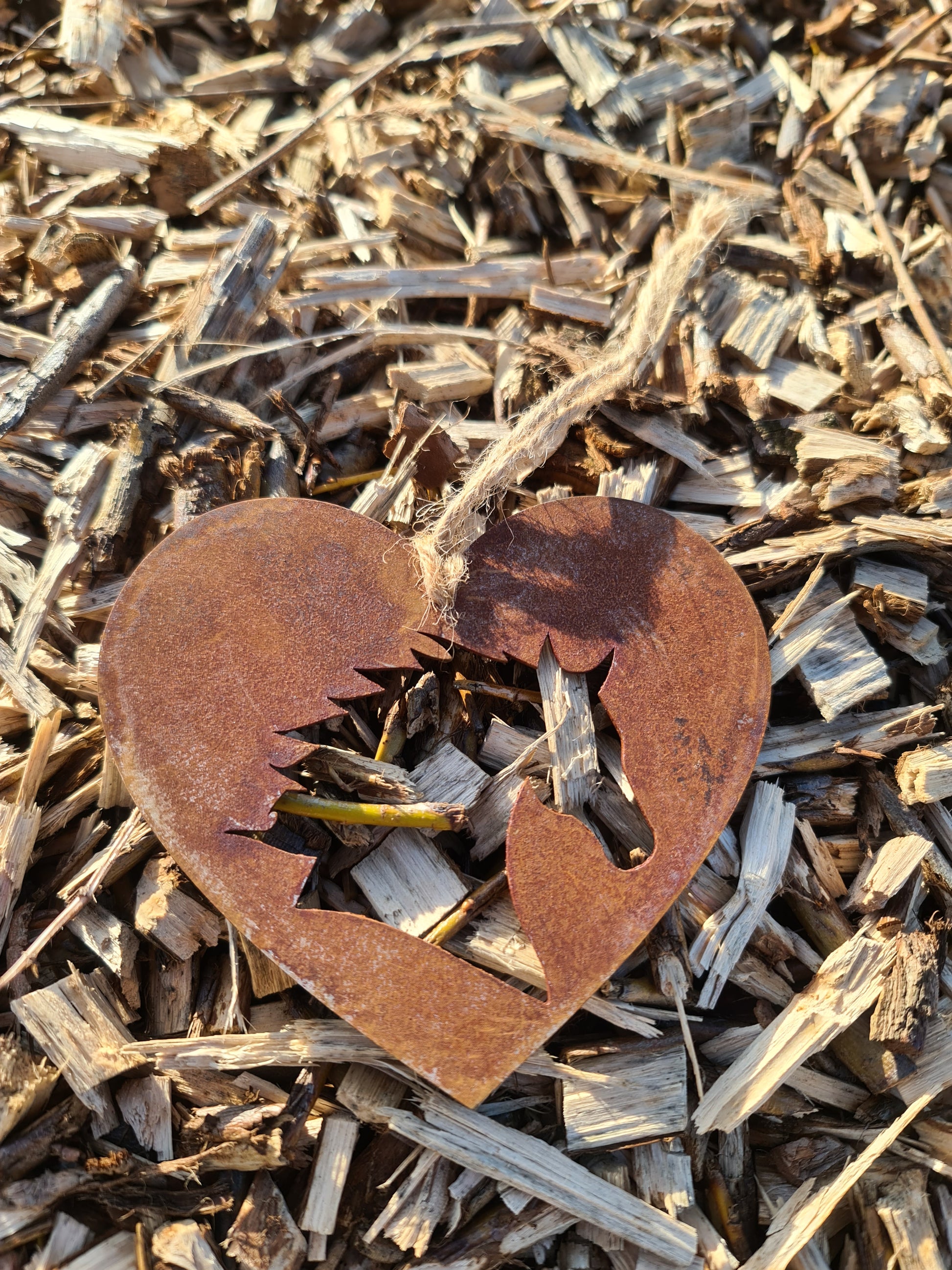 This rustic heart-shaped ornament features a detailed silhouette of a horse's head cut out in the center. The weathered, rusted finish adds a natural charm, while the jute twine provides a simple yet elegant way to hang it. Perfect for outdoor or rustic-themed decor.