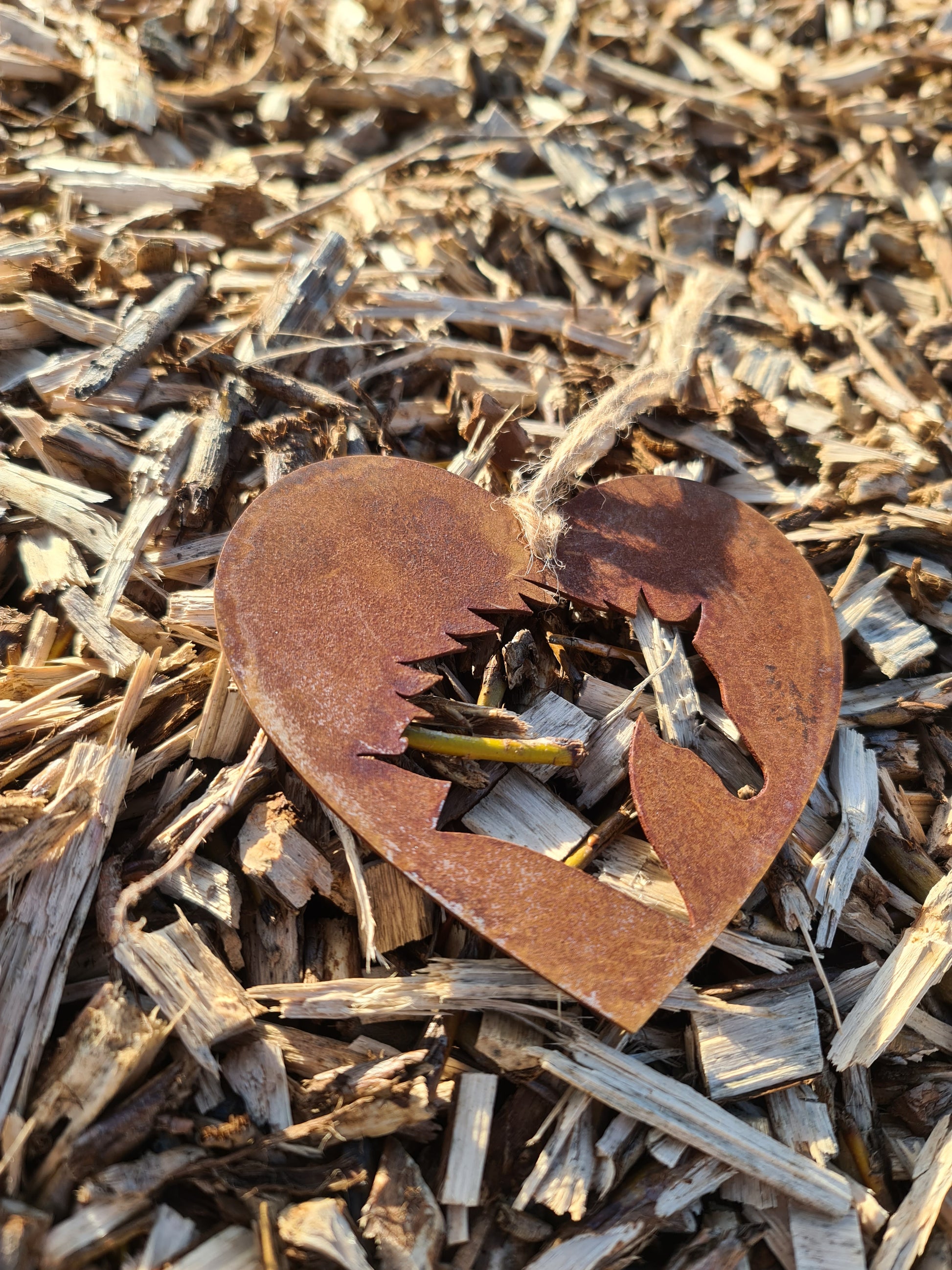 This rustic heart-shaped ornament features a detailed silhouette of a horse's head cut out in the center. The weathered, rusted finish adds a natural charm, while the jute twine provides a simple yet elegant way to hang it. Perfect for outdoor or rustic-themed decor.