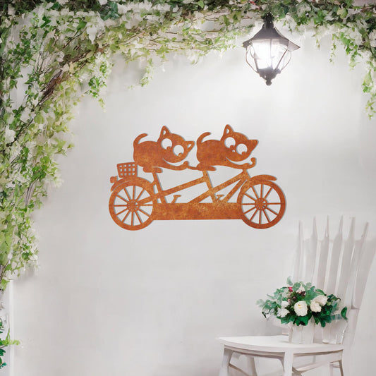 A charming metal wall art design depicting two playful cats riding a tandem bicycle, capturing a whimsical and fun moment with intricate details of the bike and expressive cat figures.