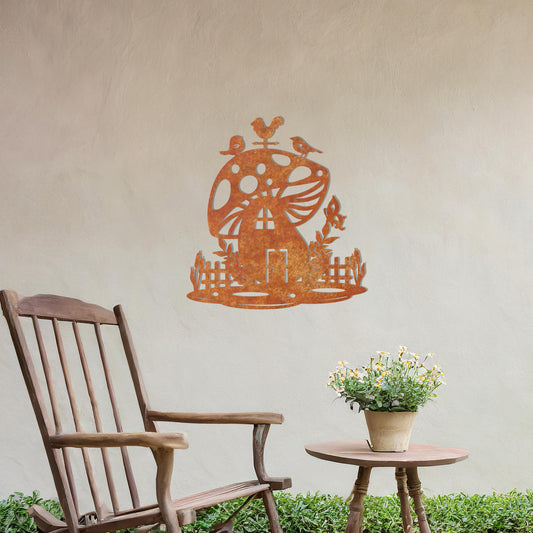 Metal garden decoration featuring a whimsical mushroom house surrounded by a picket fence, foliage, and birds perched on top, adding a playful and enchanting touch to outdoor walls or garden spaces.
