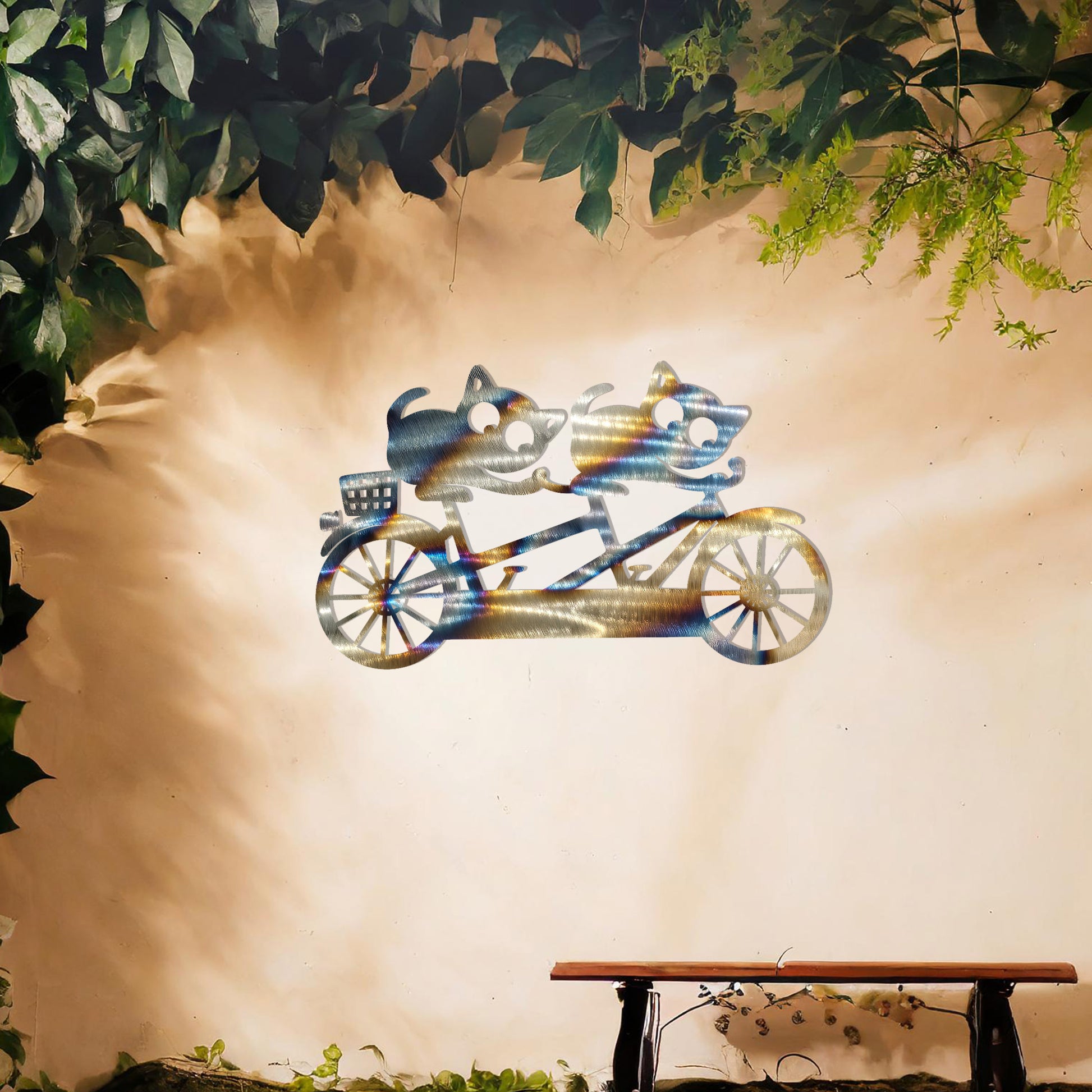 A charming metal wall art design depicting two playful cats riding a tandem bicycle, capturing a whimsical and fun moment with intricate details of the bike and expressive cat figures.