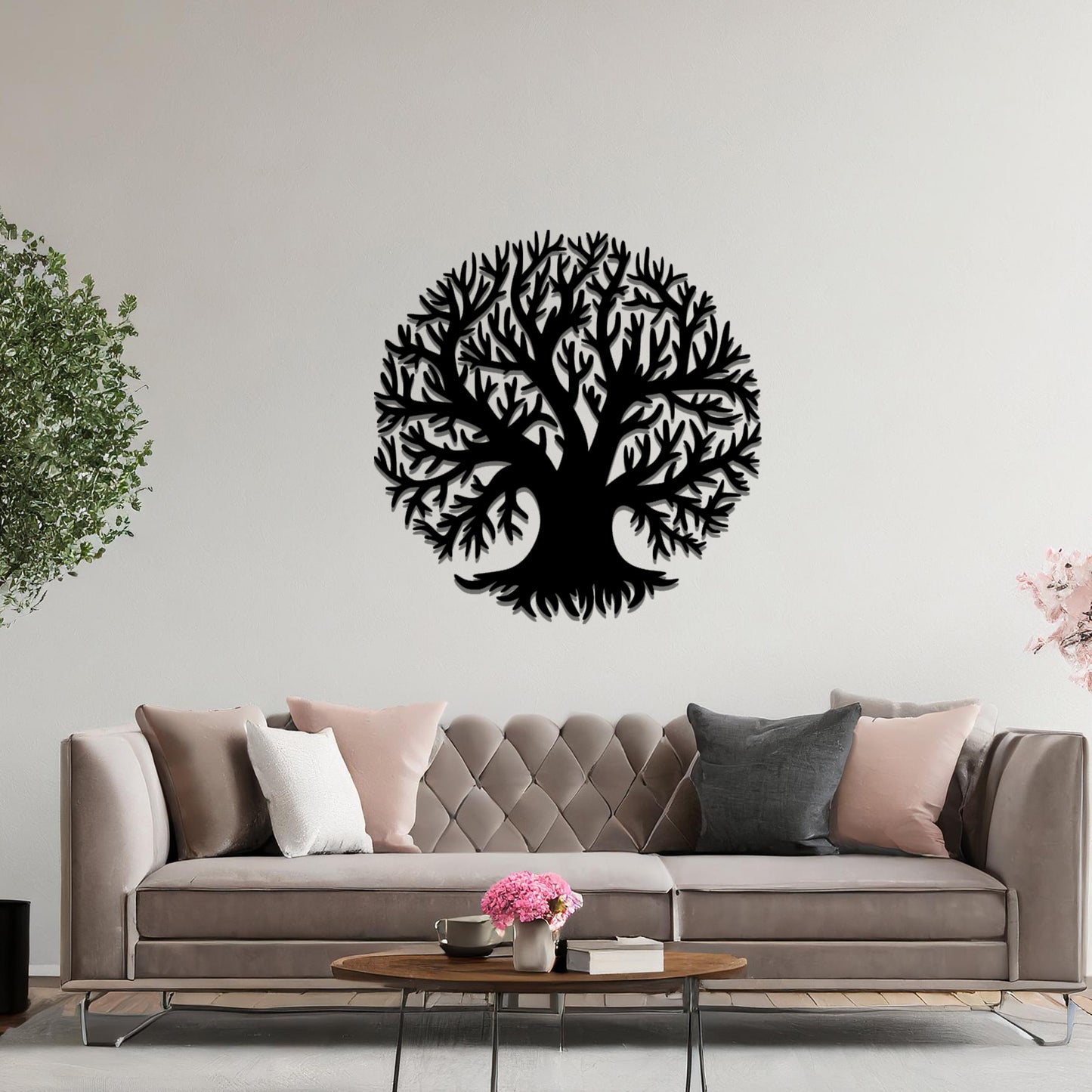 Metal wall art featuring a circular tree design with intricate branches and roots, crafted with precise laser-cut detailing, placed on a neutral wall within modern decor.