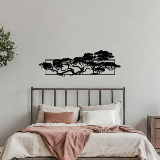 Metal wall art featuring a landscape design of a silhouette of trees with intricate branches, framed within a rectangular panel, crafted with precise laser-cut techniques, displayed on a neutral wall within modern decor.