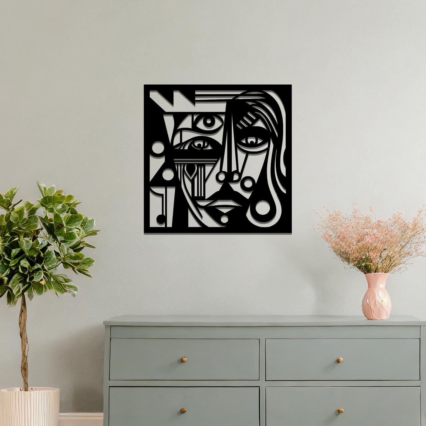 Abstract geometric face design with bold lines, circles, and angles, creating a striking, stylized portrait. The art is displayed on a neutral wall in a modern room setting with minimalistic decor.