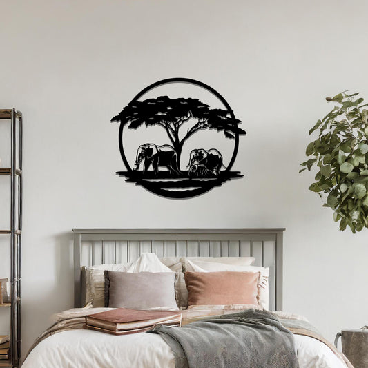 Metal wall art featuring a design of two elephants beneath a tree, framed in a circular shape. The art is placed on a neutral wall within modern room decor, creating a serene and nature-inspired atmosphere.