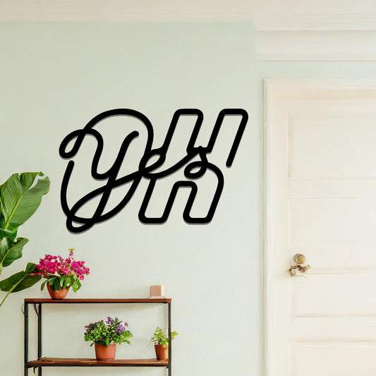 A contemporary metal wall art design featuring the bold, interwoven letters "Oh Yes" in a flowing, cursive style. The artwork is displayed on a neutral wall in a modern room setting.