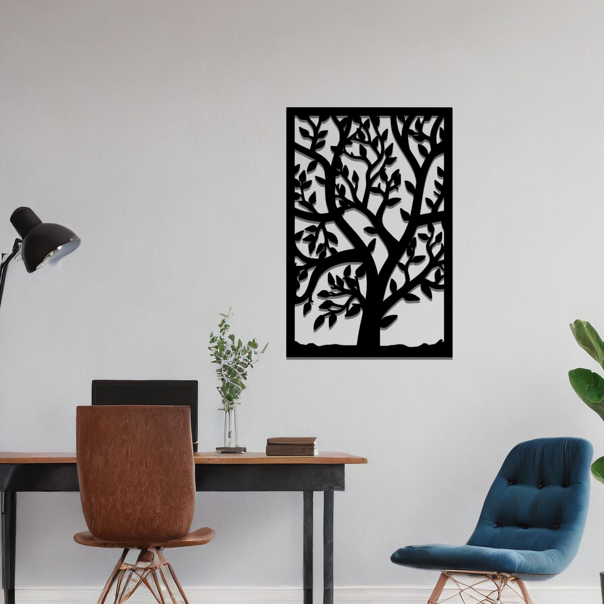 Metal wall art featuring a tree with detailed branches and leaves, enclosed in a rectangular frame. The artwork is displayed on a neutral wall within a modern office space, complemented by a stylish desk, chair, and greenery.