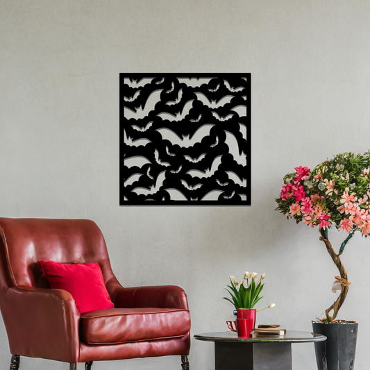 Metal wall art featuring a square design with a cluster of bat silhouettes in various flying poses, mounted on a neutral wall within modern office decor. The intricate and dynamic design adds a bold, creative, and slightly edgy touch to the space.