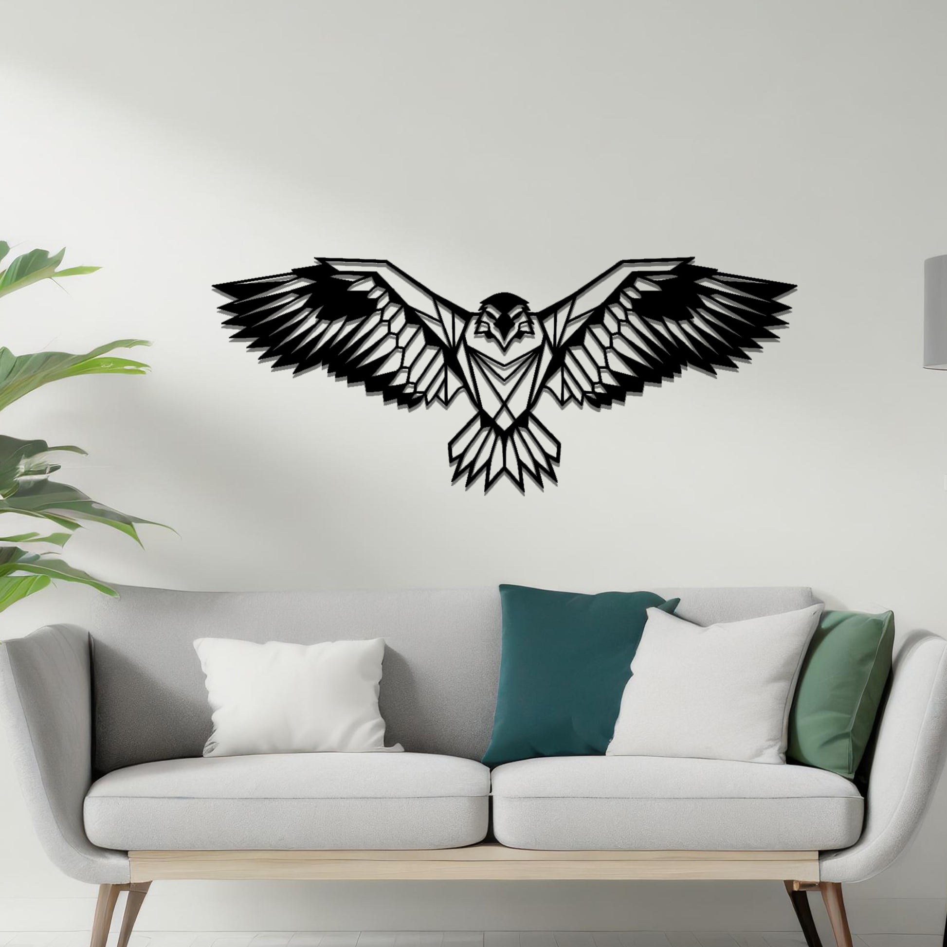 Metal wall art featuring a geometric eagle design with outstretched wings and intricate detailing, crafted with precise laser-cut techniques, displayed on a neutral wall within modern decor.