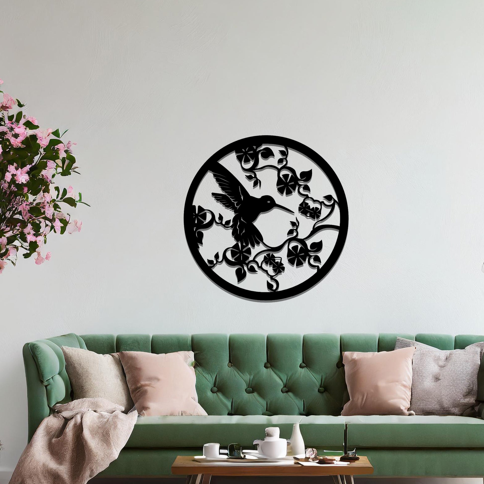 Metal wall art featuring a bird perched on floral vines in a circular design. The intricate patterns of the leaves and branches are beautifully balanced, creating a harmonious look. The art is placed on a neutral wall within modern room decor.