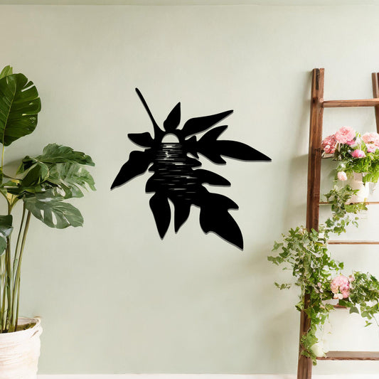 Metal wall art featuring a stylised leaf design with intricate line details, incorporating a circular motif resembling the sun or moon, mounted on a neutral wall. The organic form and minimalist design add a serene and artistic touch to the space.