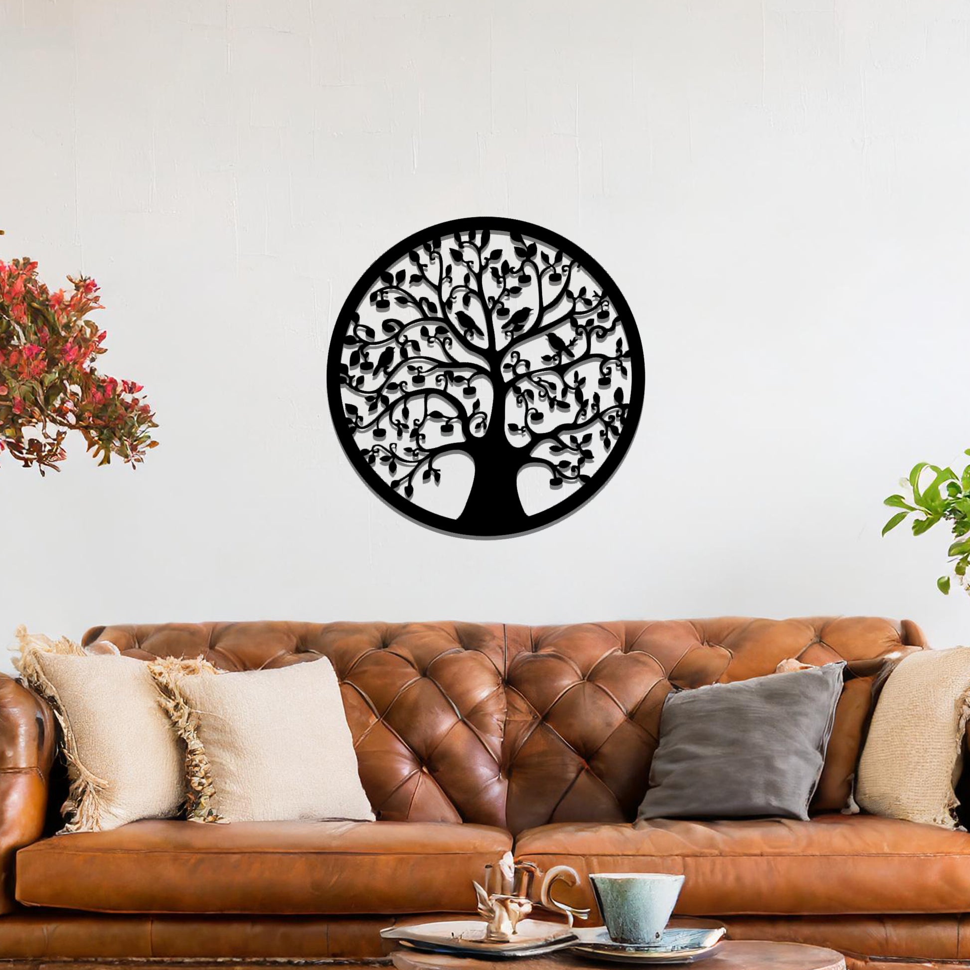 Metal wall art featuring a circular tree design with intricate branches and leaves, showcasing a detailed and balanced composition, displayed on a neutral wall within modern decor.