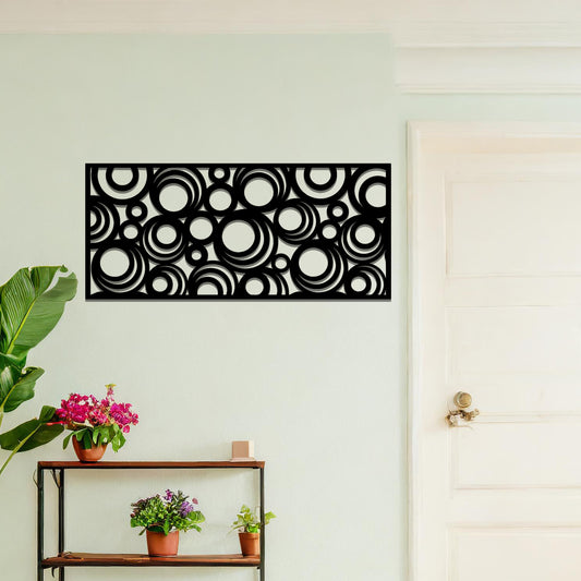 Metal wall art featuring an intricate pattern of overlapping circles in various sizes. The design is set against a neutral wall in a modern living room space, adding a touch of contemporary elegance to the decor.
