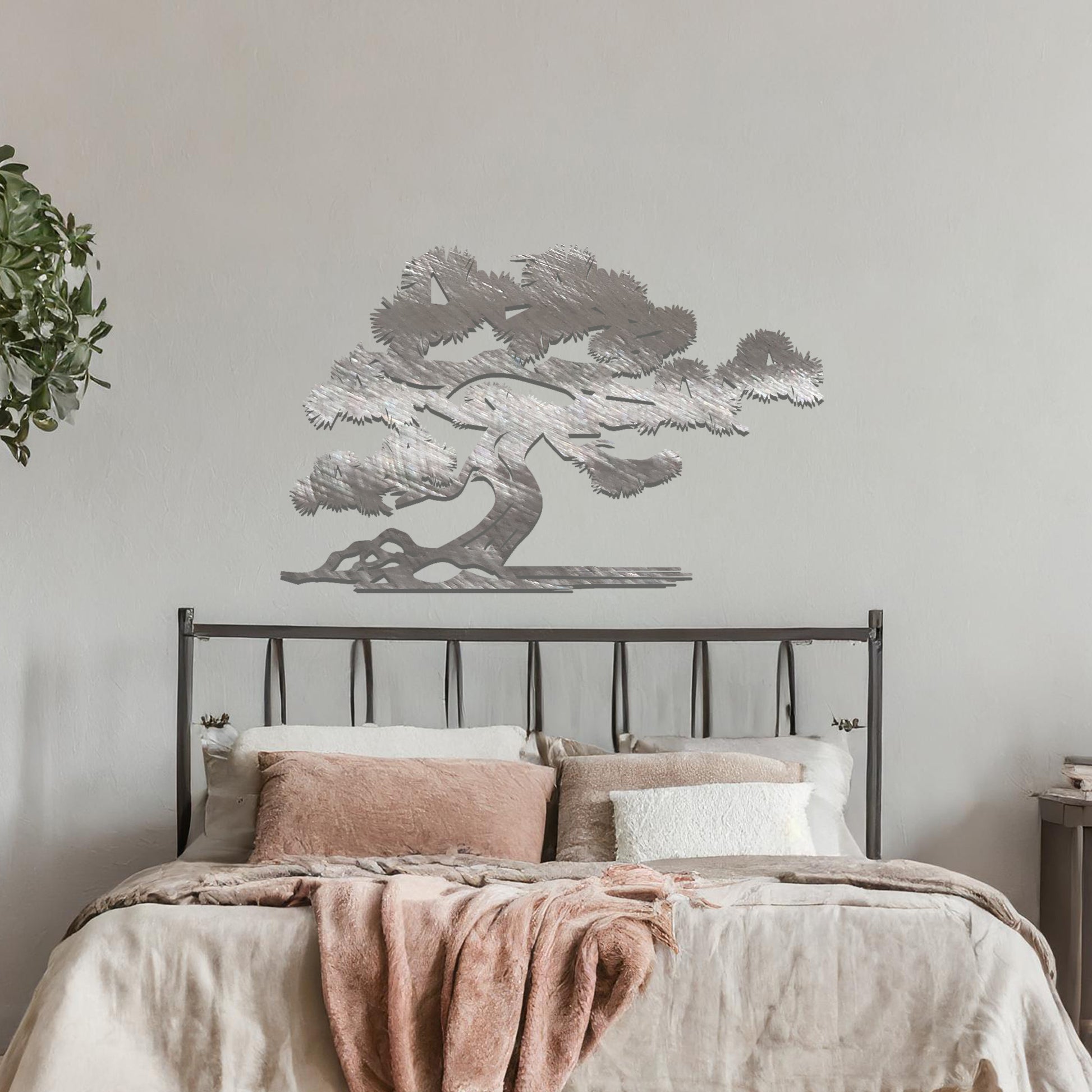 Metal wall art showcasing a serene bonsai tree design with flowing branches and a textured trunk, adding an artistic and calming element to the living space.