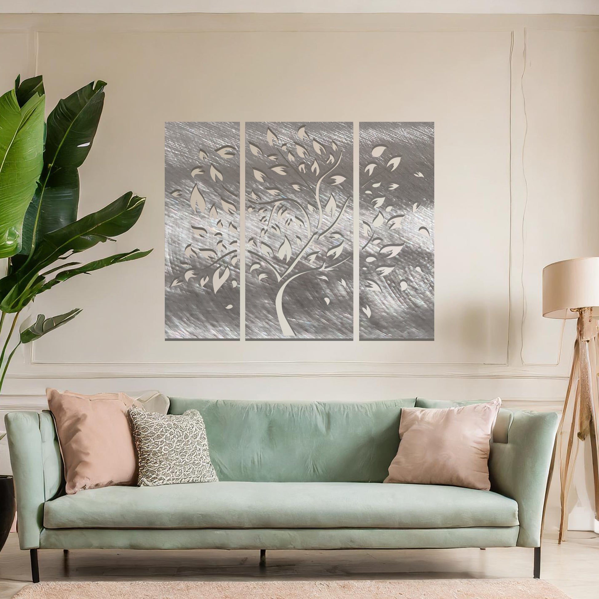 Metal wall art featuring a three-panel tree design with curved branches and delicate leaves, crafted with precise laser-cut detailing, displayed on a neutral wall within modern decor.
