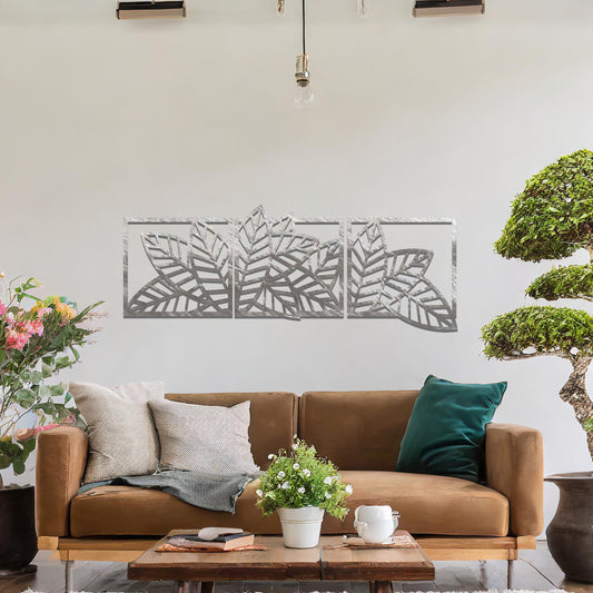 Metal wall art featuring a three-panel design with overlapping leaf patterns, mounted on a neutral wall within modern office decor. The intricate detailing and natural motif of the wall art add an elegant and contemporary touch to the space's aesthetic.