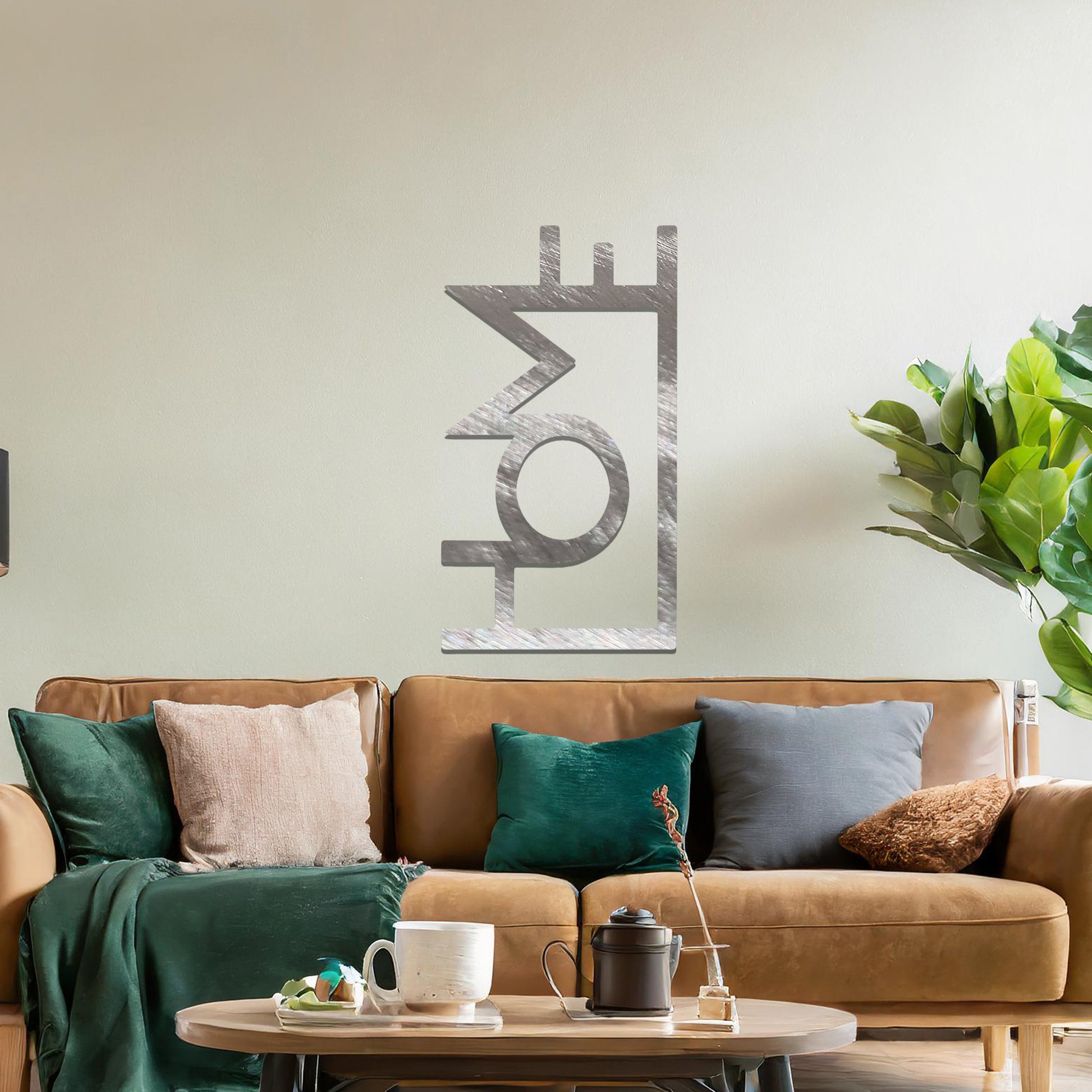A modern metal wall art design featuring the word "HOME" in bold, geometric typography with an innovative, angular twist. The artwork is displayed on a neutral wall in a contemporary room setting.