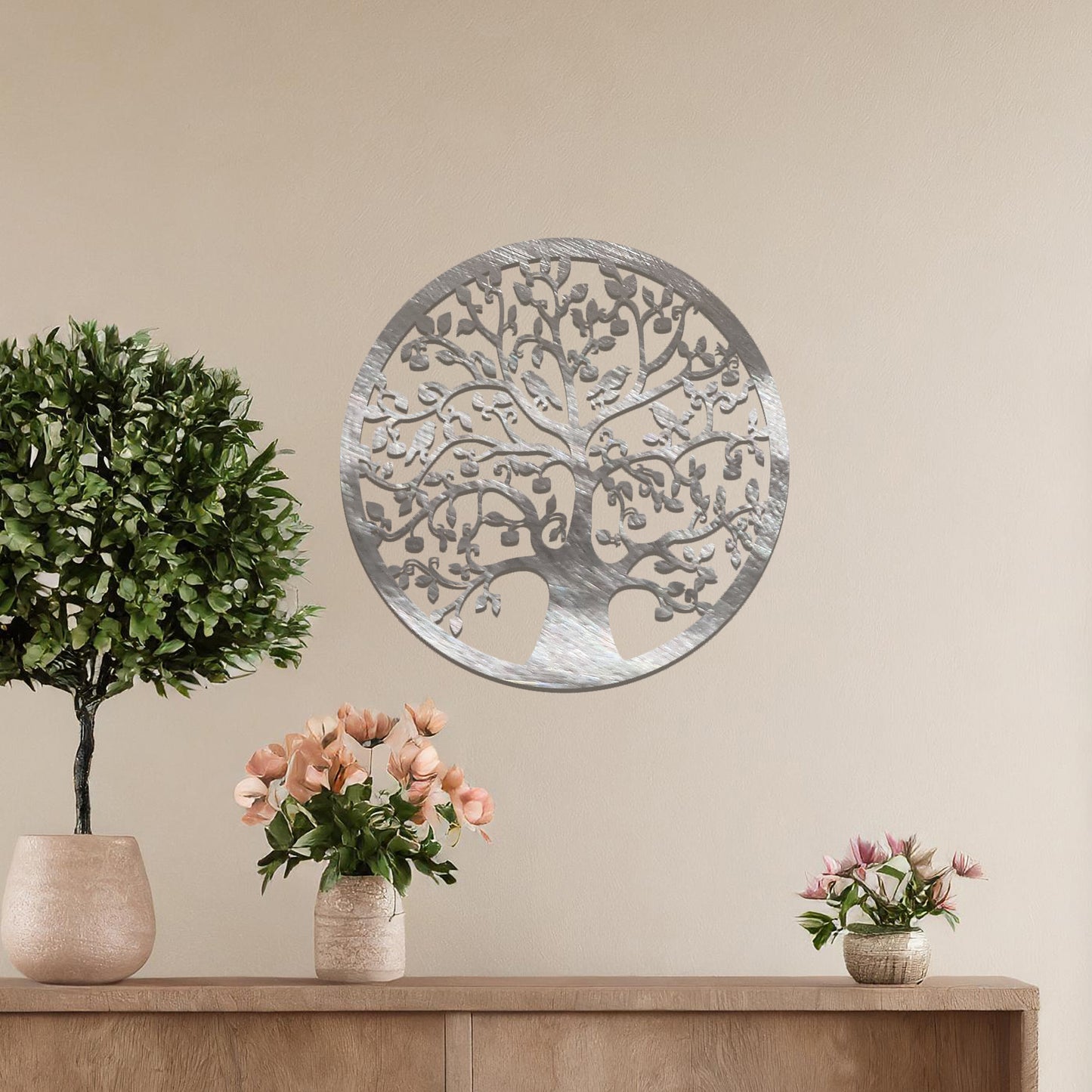 Metal wall art featuring a circular tree design with intricate branches and leaves, showcasing a detailed and balanced composition, displayed on a neutral wall within modern decor.