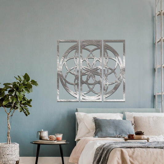 A three-panel metal wall art featuring a geometric floral pattern with interlocking circles and a star-shaped center. The design is displayed on a neutral wall, enhancing the room's modern aesthetic with its elegant symmetry.