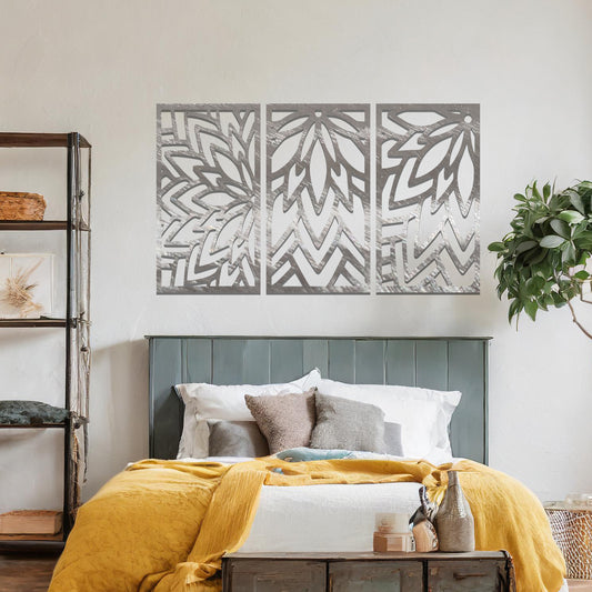 Metal wall art featuring a three-panel design with floral-inspired geometric patterns, crafted with precise laser-cut detailing, displayed on a neutral wall within modern decor.